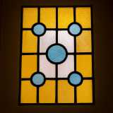 A colpirci di pi� � per� la porta che sancisce la fine dell�andito: � infatti sormontata da una vetrata in stile liberty che accosta figure geometriche blu e gialle, oltre le quali sembra celarsi una luce accecante